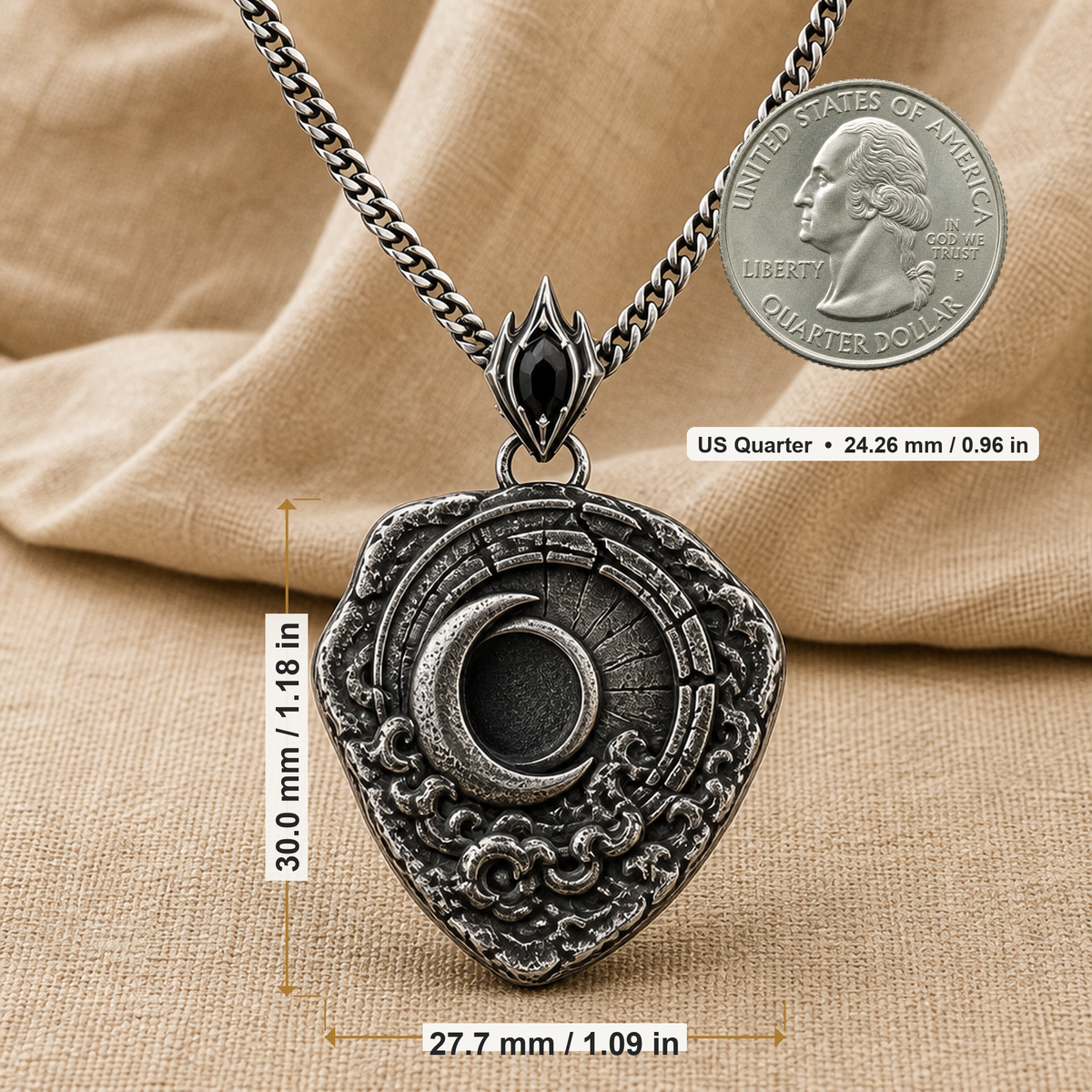 Oxidized 925 sterling silver shield pendant with raised crescent moon, dark circular center, textured relief details, pointed bail, and curb chain on beige fabric.