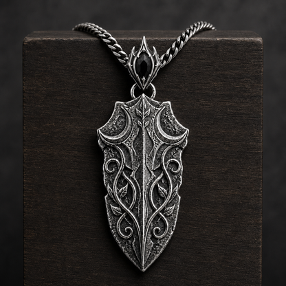 Oxidized 925 sterling silver pendant necklace with a blade-shaped relic pendant, crescent moon details, raised vine engraving, decorative bail and curb chain on a black background.