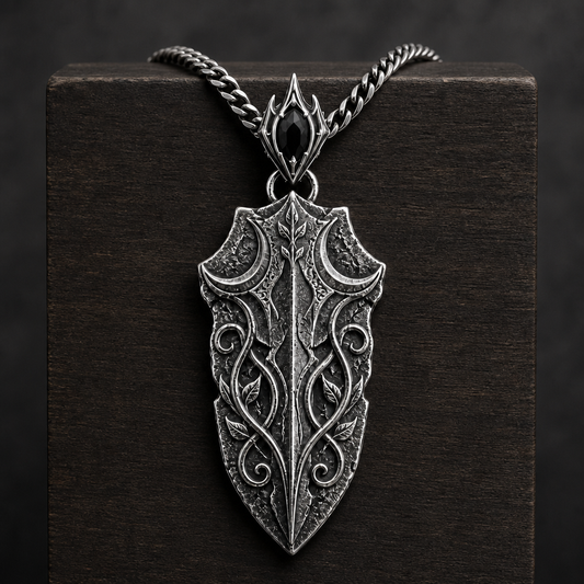 Oxidized 925 sterling silver pendant necklace with a blade-shaped relic pendant, crescent moon details, raised vine engraving, decorative bail and curb chain on a black background.