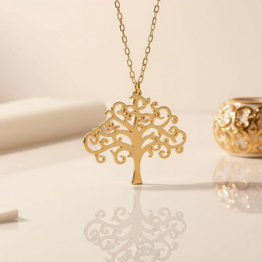 Gold Plated Silver scrollwork Tree of Life pendant on a reflective surface